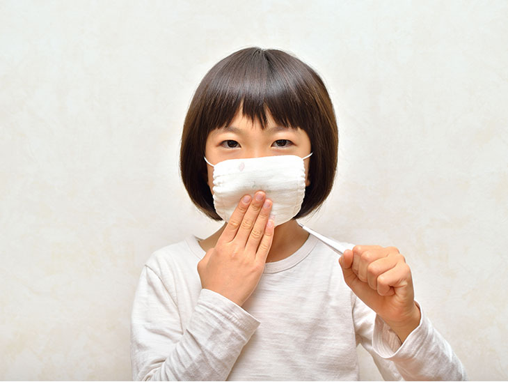 体温計を持ってマスクをする女の子