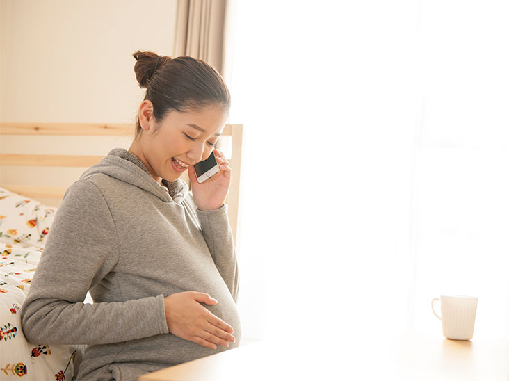 電話で喋る妊婦さん