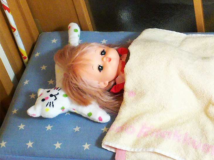 完成したヌイグルミをまくらにして寝かされた人形