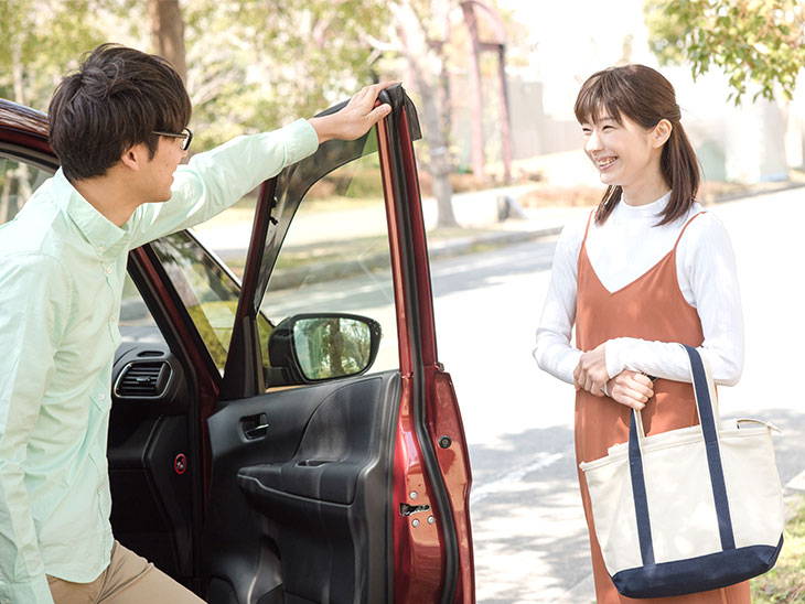 車に乗る男性とバッグを持った女性