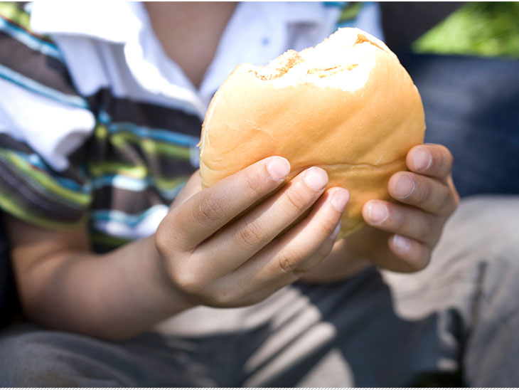 ハンバーガーを食べる子供の手