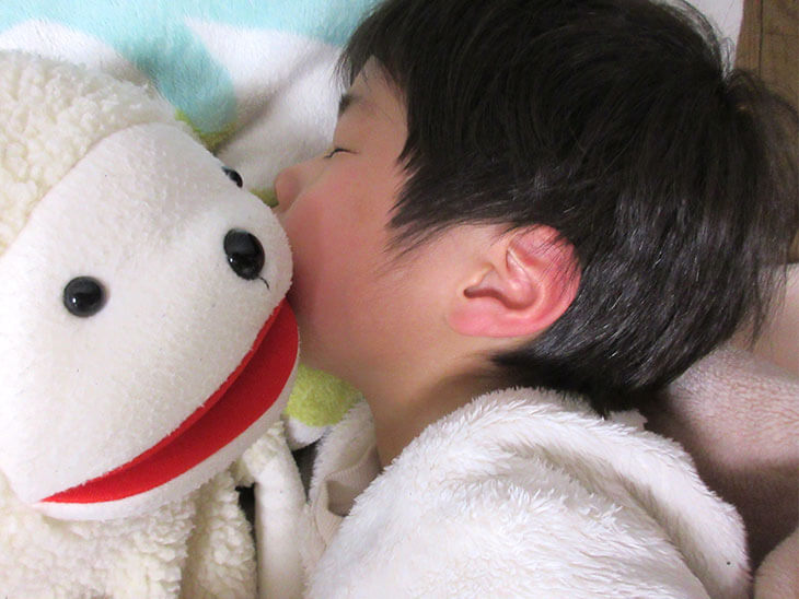 ぬいぐるみと寝る子供