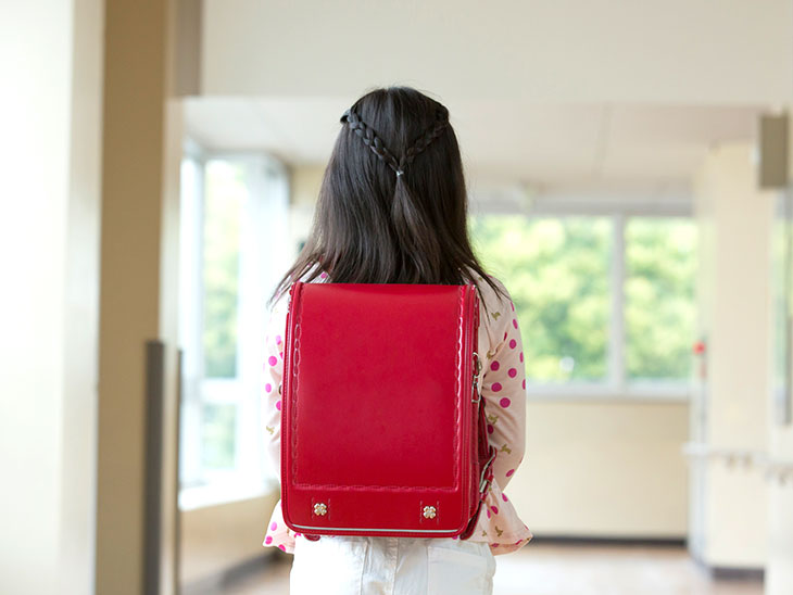 一人で歩く小学生の女の子の後ろ姿