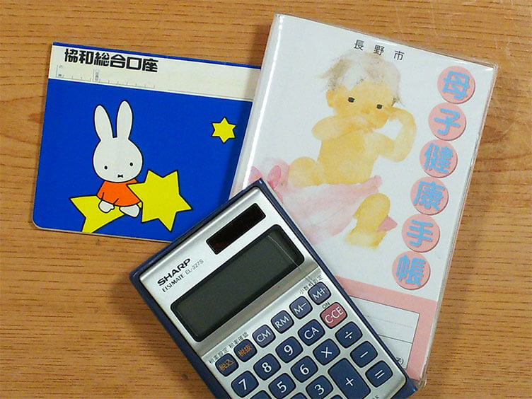 子供の通帳と母子手帳と電卓