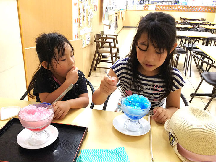 合成着色料のシロップを使ったかき氷を食べる子供の写真