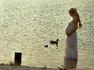 水辺に立つ妊婦