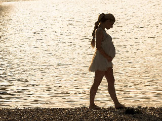 水辺を歩く妊婦