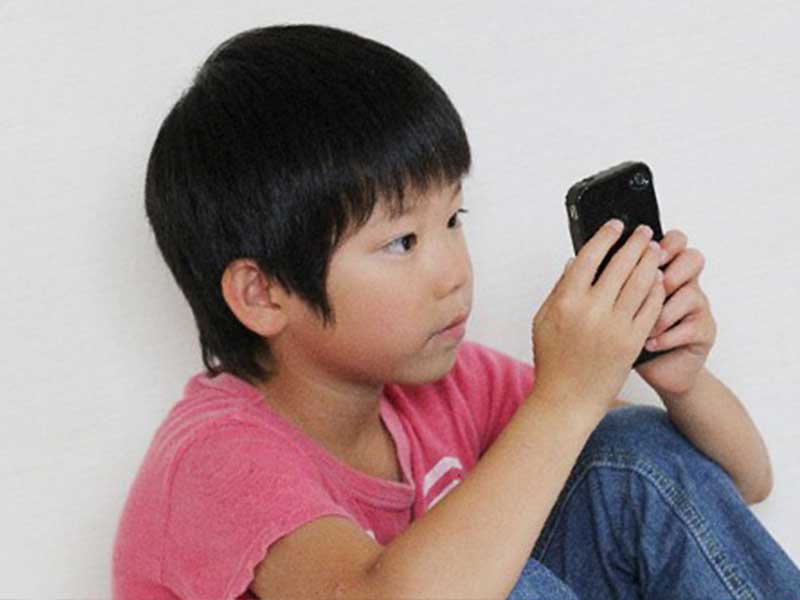スマホでゲームを見る少年
