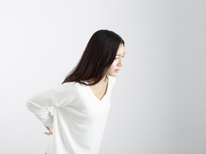 腰をおさえている妊娠している女性