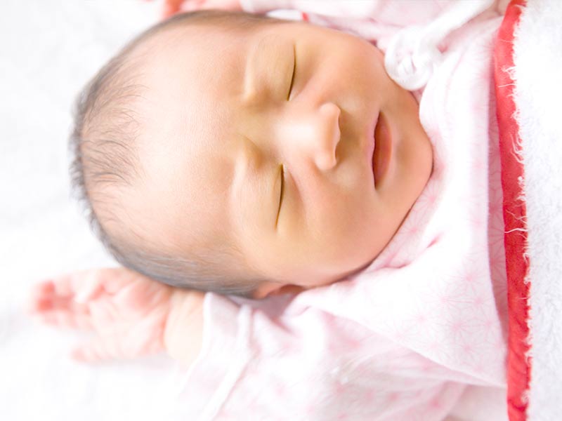 布団の上にでぐっすり寝る赤ちゃん