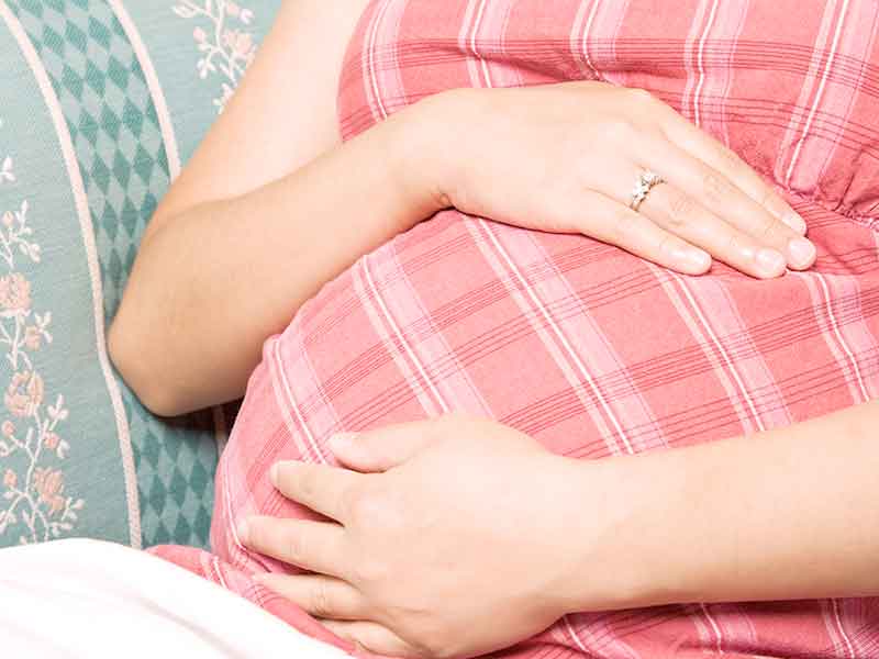 お腹に手を当てる妊婦さん