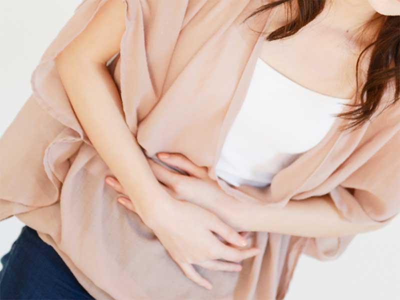 お腹を押さえている女性