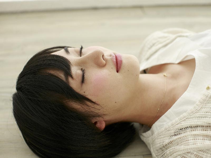 床で寝る女性