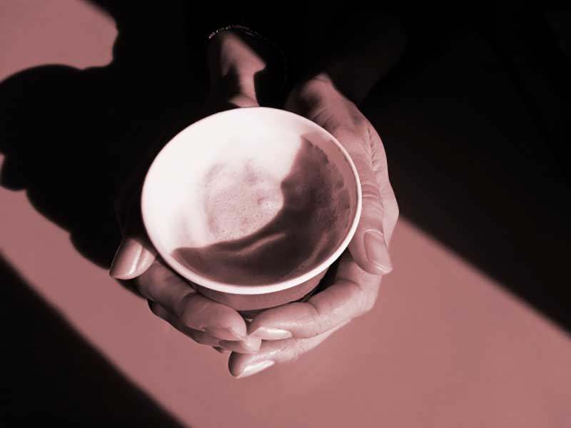 コーヒーを飲んでいる女の人の手