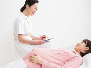 妊婦の問診をする助産師