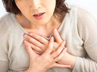 胸を押さえる女性