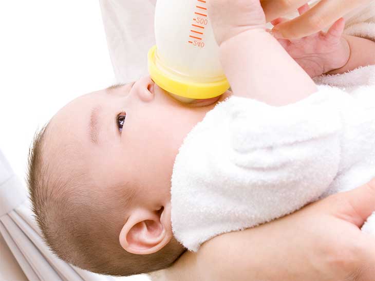 母親から哺乳瓶でミルクを飲ませてもらっている母親