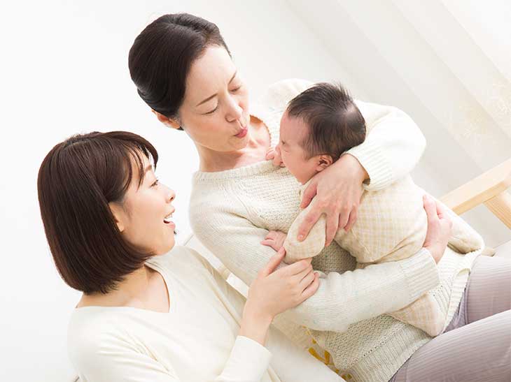 母親に赤ちゃんの面倒を見てもらっている若いママ
