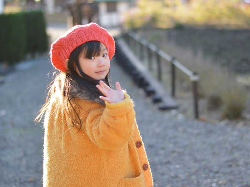 手を振ってバイバイをしている女の子
